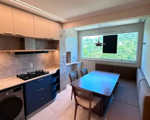 Copa com mesa de jantar em madeira e banco estofado junto à janela