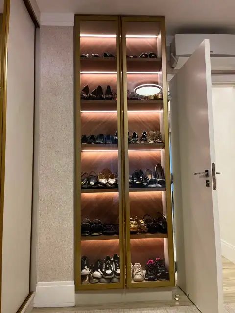 Cozinha corredor com acabamento dourado, mármore e sala de jantar ao fundo
