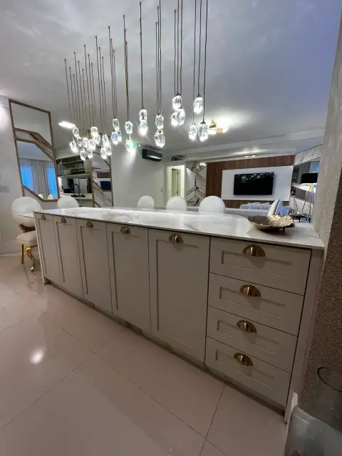 Detalhe de forno, micro-ondas e geladeira embutidos em marcenaria clara