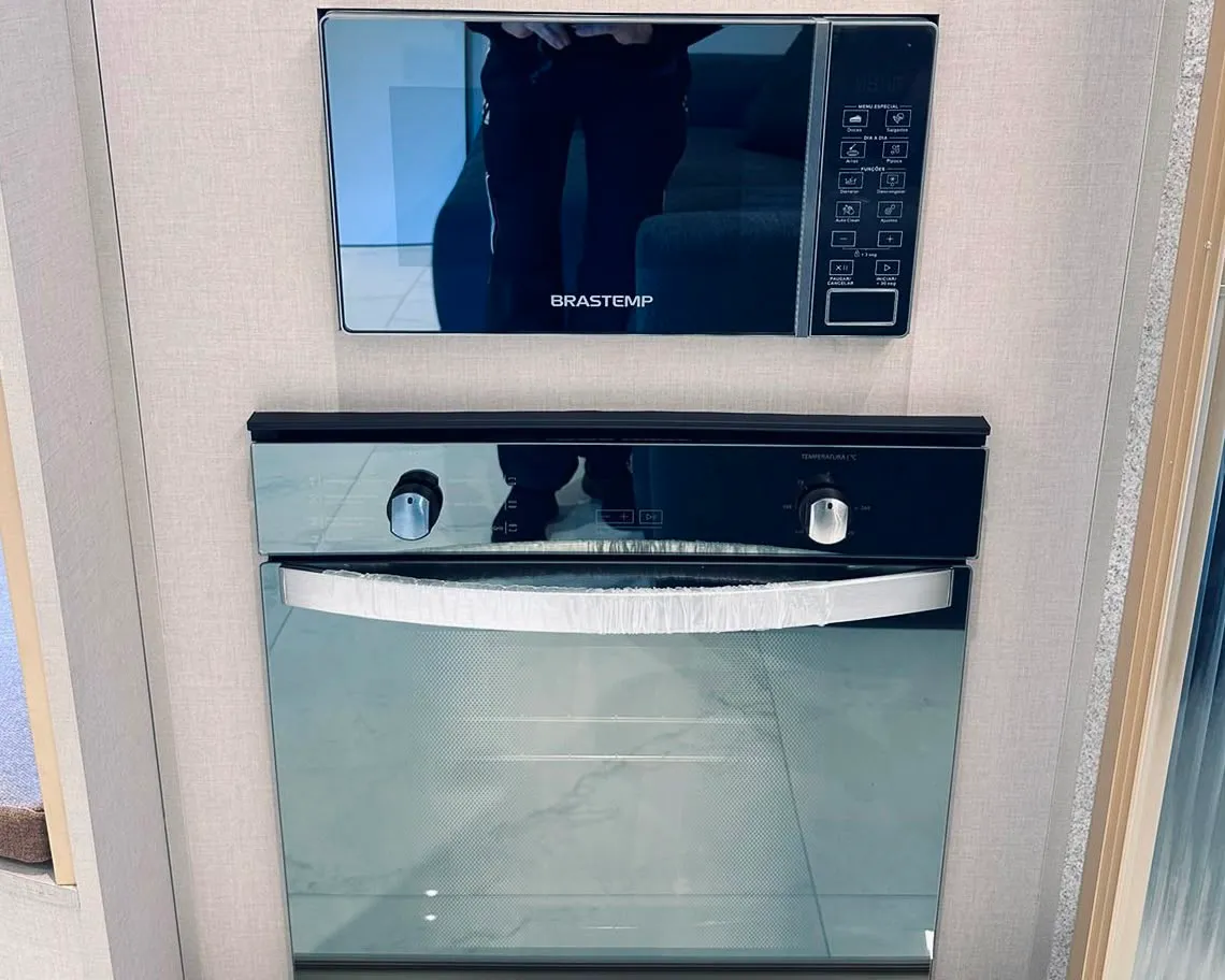 Detalhe de forno e micro-ondas de embutir integrados à marcenaria