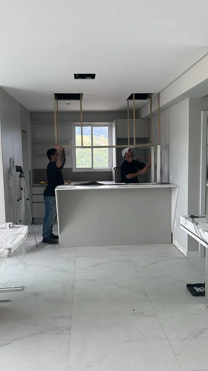 Profissional da equipe MPF Marcenaria instalando gavetas em armário planejado