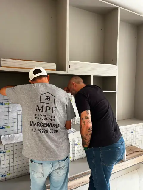 Equipe MPF Projetos e Execuções instalando estante planejada em obra