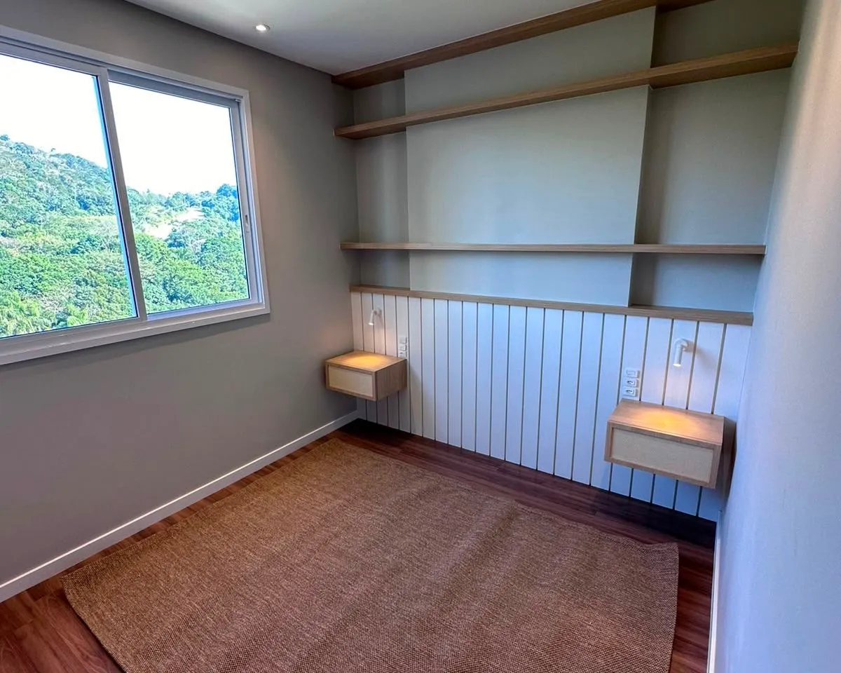 Quarto com criados-mudos suspensos em marcenaria, prateleiras em madeira e vista para a mata