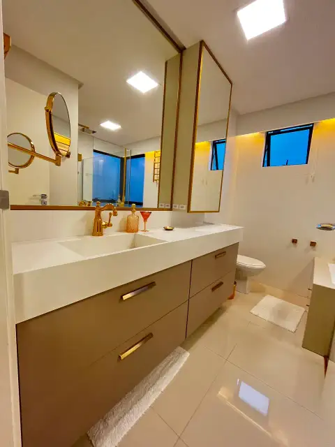 Closet com sapateira em vidro e friso dourado iluminada internamente