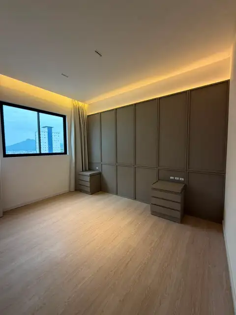 Quarto vazio com parede curva em madeira, iluminação indireta e piso de madeira claro