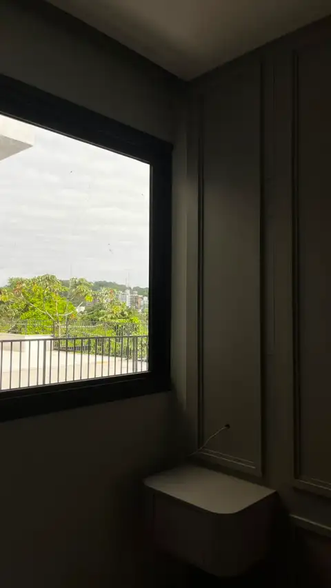 Quarto em fase final de acabamento com marcenaria embutida e vista noturna