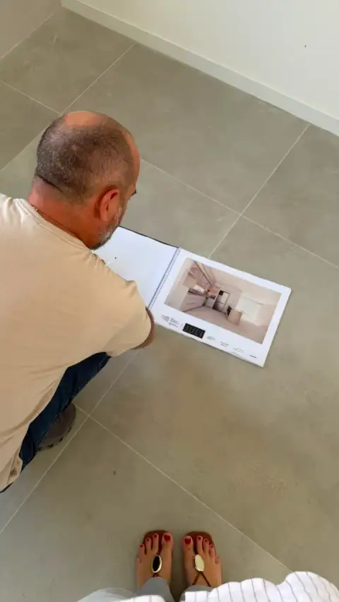 Cliente avaliando catálogo de projeto de marcenaria durante visita técnica
